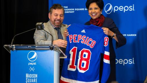Three people holding up a PepsiCo jersey left to right: The Madison Square Garden Company Executive Chairman and CEO Jim Dolan; PepsiCo Chairman and CEO Indra Nooyi
