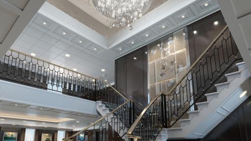 The Grand Staircase of the reimagined Regatta-Class ships with a giant chandelier in the ceiling.