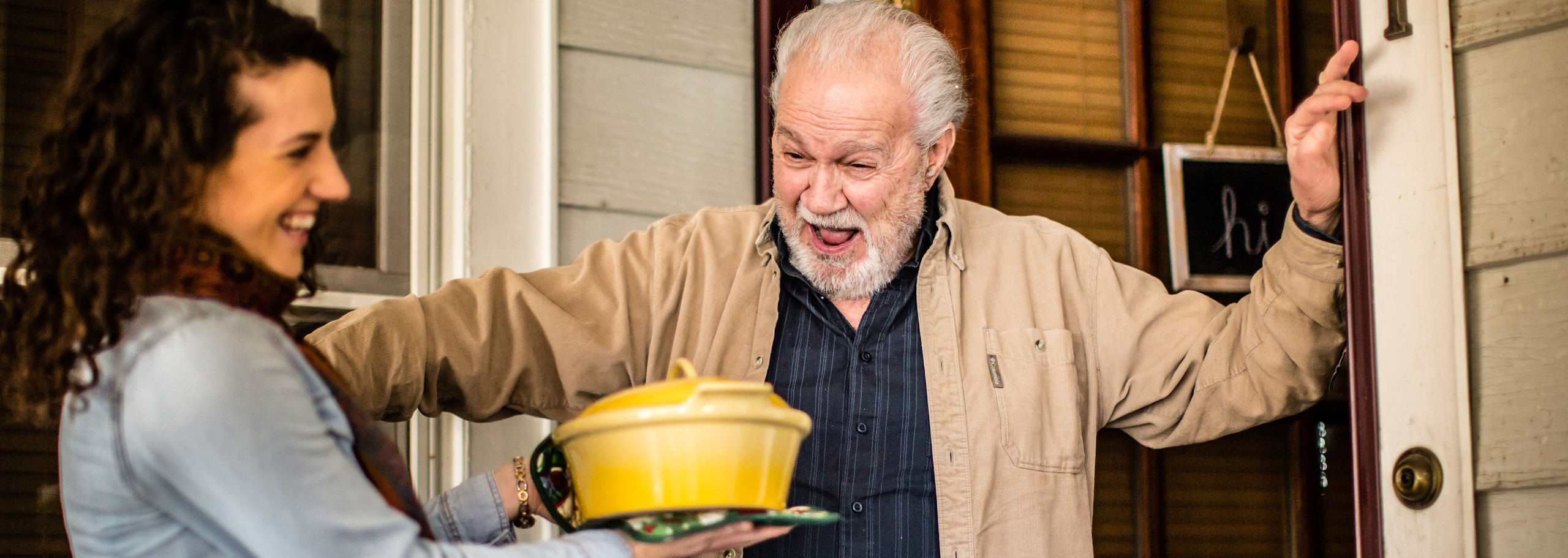 Woman giving elderly man food in bake-wear