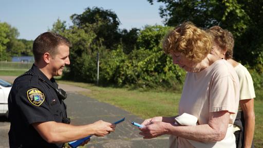 Male officer handing out Hershey's candy bars to elderly women