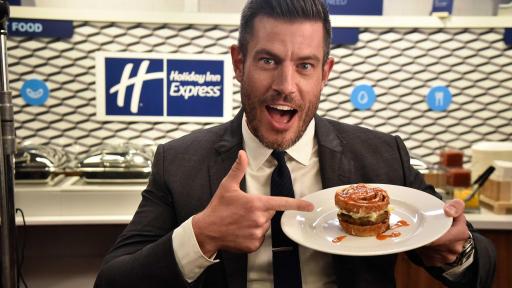 A split cinnamon roll with eggs, sausage and hot sauce