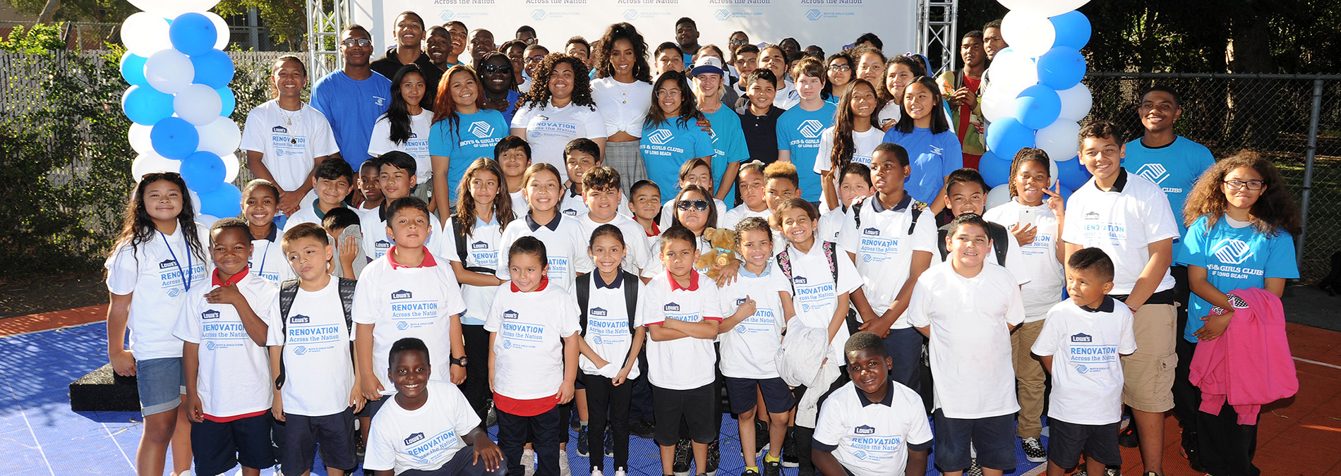 Group of volunteers standing together with Kelly Rowland
