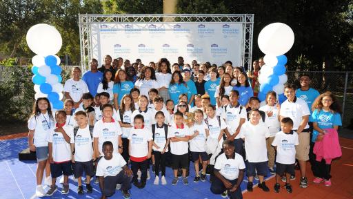 Group of volunteers standing together with Kelly Rowland.