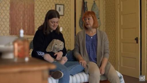 Mom sitting with daughter on bed