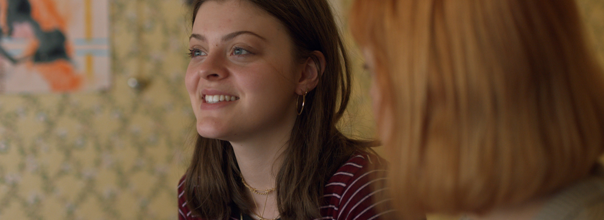 Two women talking to each other. One in focus and the other is out of focus.