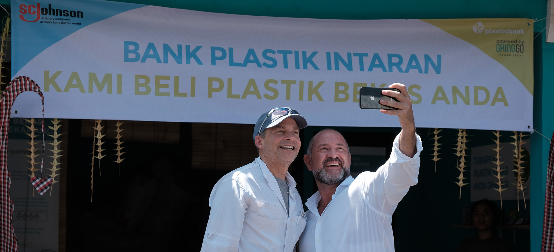 David Katz taking a selfie in front of the Plastic Bank Opening sign