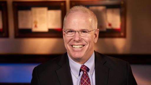 Portrait of John Thero in tie and jacket.