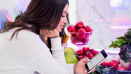 Ayesha Curry checking her email on a smartphone