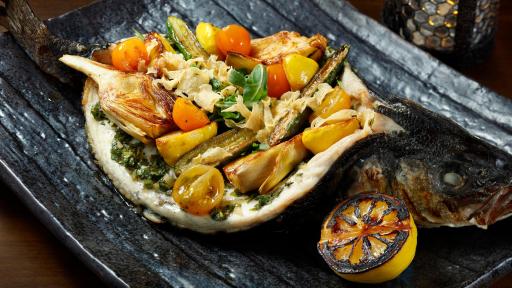 Signature Whole Fish at CATCH Las Vegas Filled with Pattypan Squash, Baby Zucchini, Heirloom Tomato, Roasted Long-Stem Artichokes, Arugula, Citrus Vinaigrette