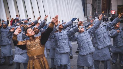 People dressed as terracotta warriors hold a pose of the Terracotta Army near One World Trade