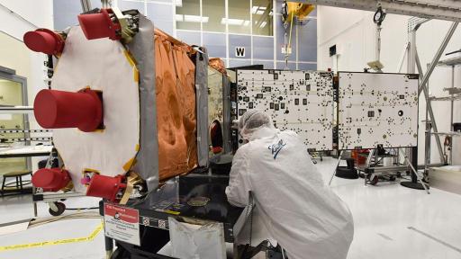 Ball Aerospace engineer dressed in a white smocks works on GPIM, a small satellite built for NASA, during solar array deployment