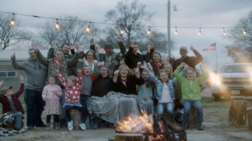 Family gathered outside in front of a fire