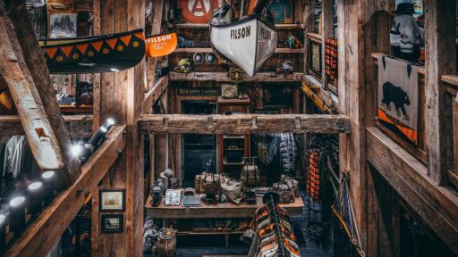 Image of the store from the second floor. Showing the wooden interior and kayaks hanging from the ceiling.