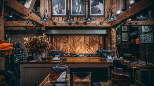 A display table with various leather goods, behind the table the registers for the store.