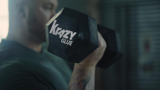 Hafthor Bjornsson behind a giant tractor tire, pointing and looking mean.