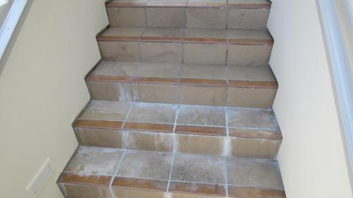 Efflorescence and damage at stair case caused by waterproofing failure.