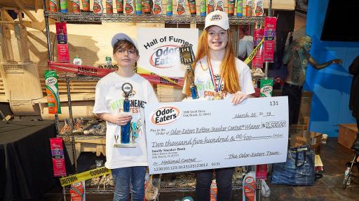 Contest winners holding trophies and check