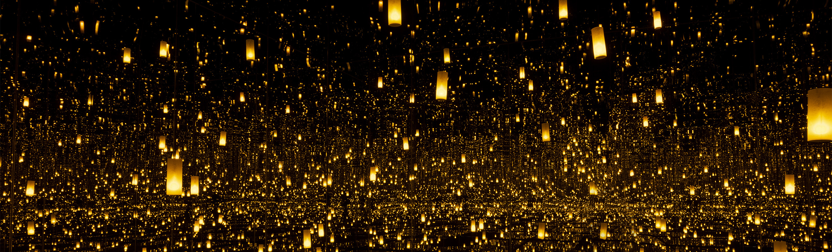 Infinity Mirrored Room: mirror-lined room illuminated by flickering golden lanterns