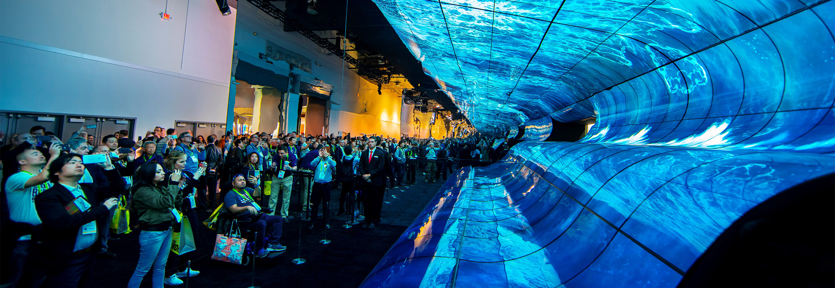 Crowd of people looking at immersive installation of eye-popping, flexible commercial displays from LG Electronics