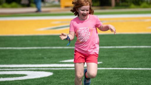 Young girl running on a field.