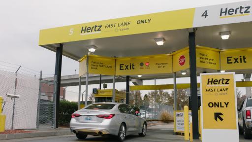 Car pulling up to the Hertz Fast Lane kiosk