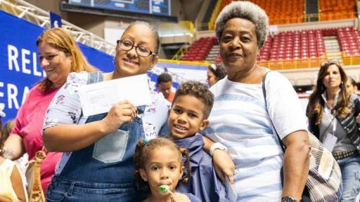 Recipients of the Puerto Rico Family Relief Program holding their $1,000 MasterCard cash card.