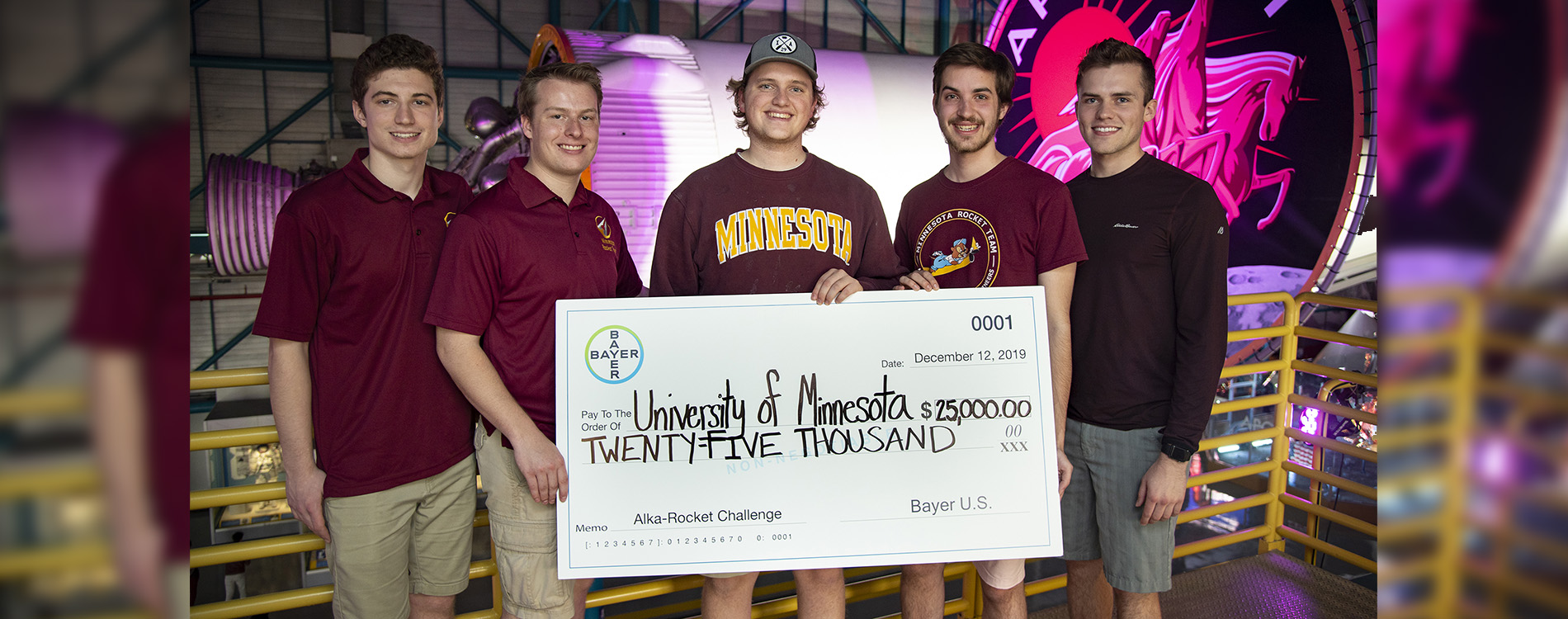 Three men holding a giant check.