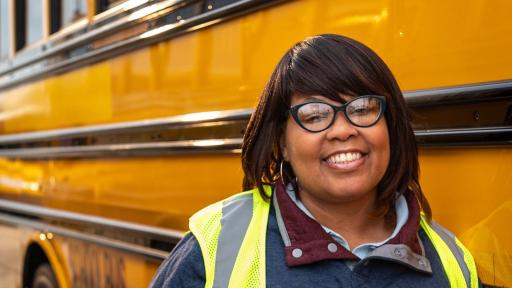 Lady bus driver beside her bus.