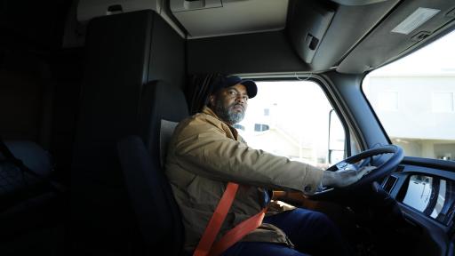 Man in the cab of his 18 wheeler truck.