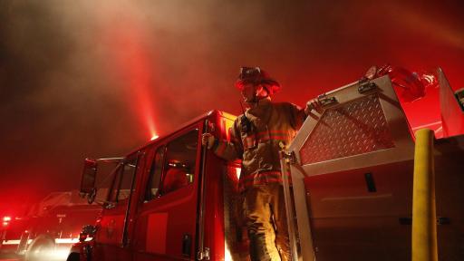 Firefighter climbing down from a firetruck