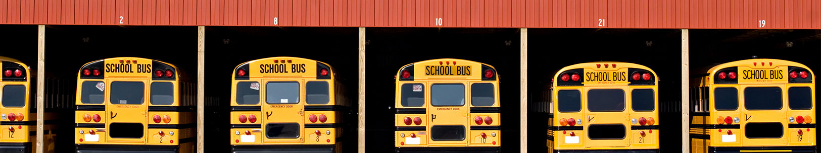 Buses lined up in their garage.