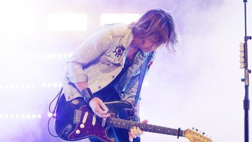 Keith Urban playing guitar on stage