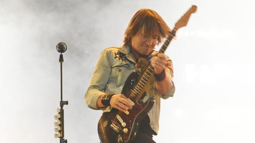 Keith Urban doing a guitar solo during a show