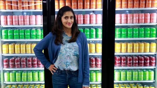 Aparna Nancherla standing in front of coolers of drinks