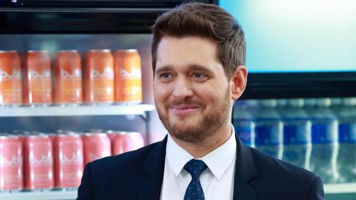 Michael Bublé standing in front of coolers of drinks.