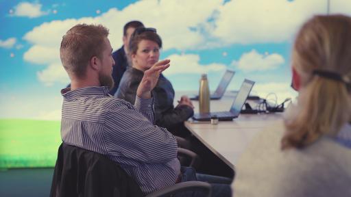 Crowe professionals seated at a table talking.
