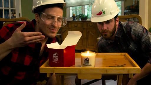 Two men around a candle.