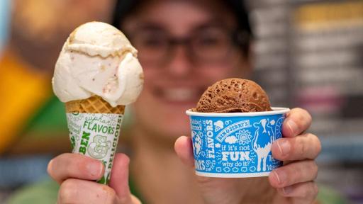 Woman smiling and holding Ben & Jerry's Ice Cream cone and cup.