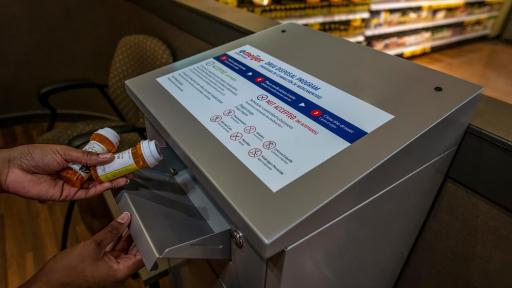 Women putting drugs inside Meijer drug take-back box