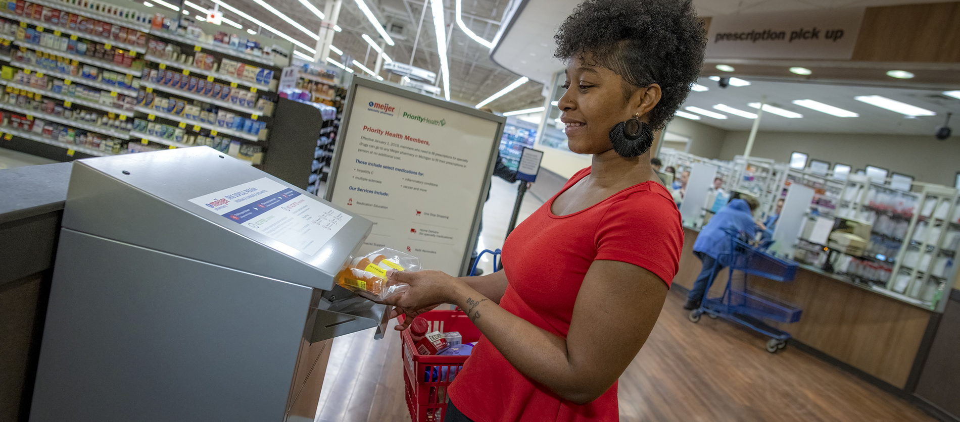 Women putting drugs inside Meijer drug take-back box