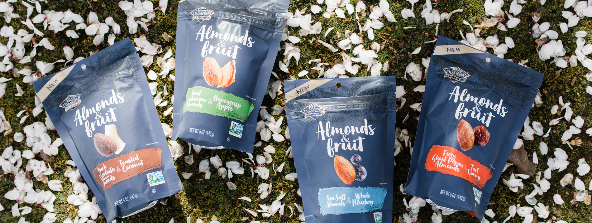 4 various flavors of Blue Diamond almonds in the grass