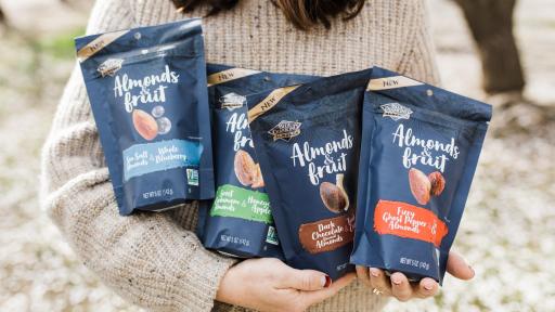 The 4 various flavors of Blue Diamond almonds in a person's arms.