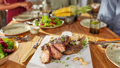 Cut steak presented on a table with various other dishes.