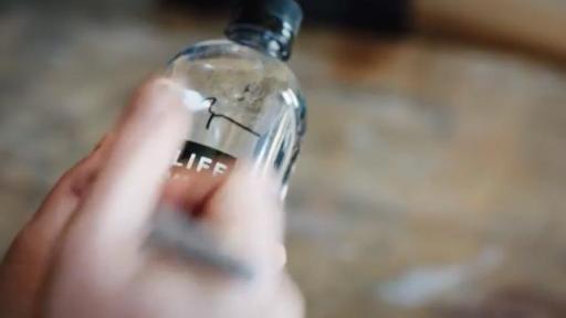 Guy signing LIFEWTR bottle