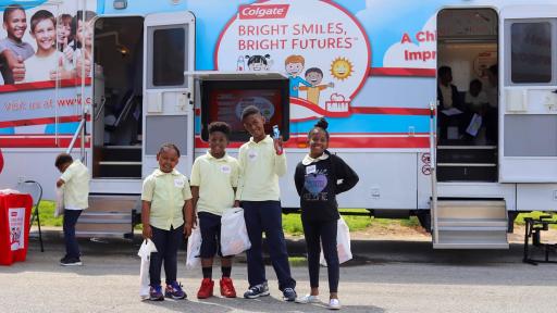 Four boys and one girl standing outside the Colgate Bright Smiles, Bright Futures® trailer