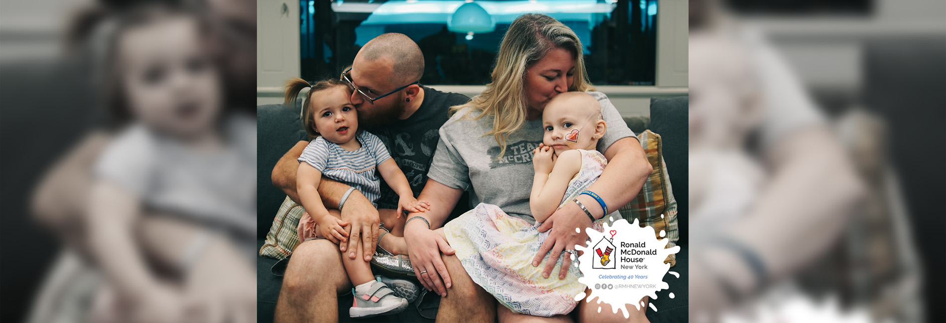 A mother and father hugging their children.