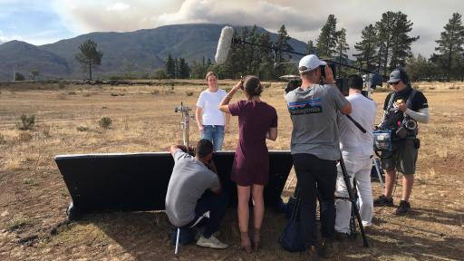 Filming under a cloudy sky, mountain range in the back
