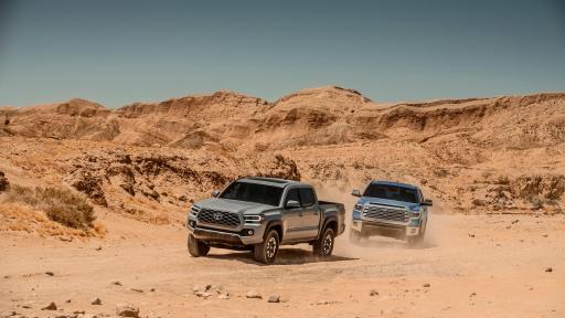 Two trucks driving in the desert