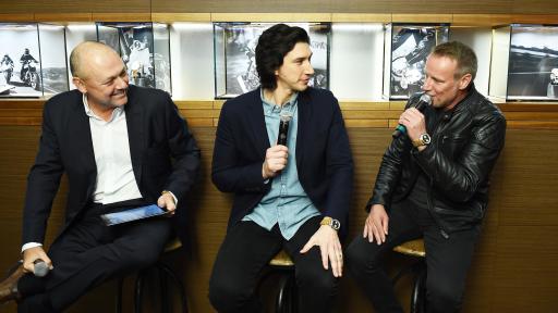 Three men sitting together and talking into microphones