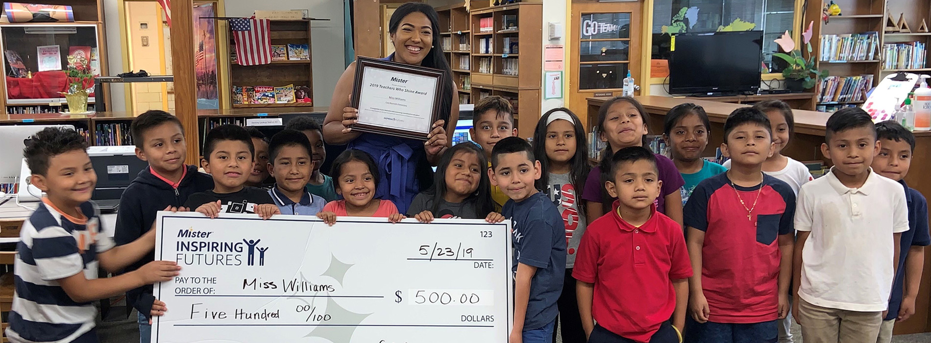 Teachers and children holding up a giant check